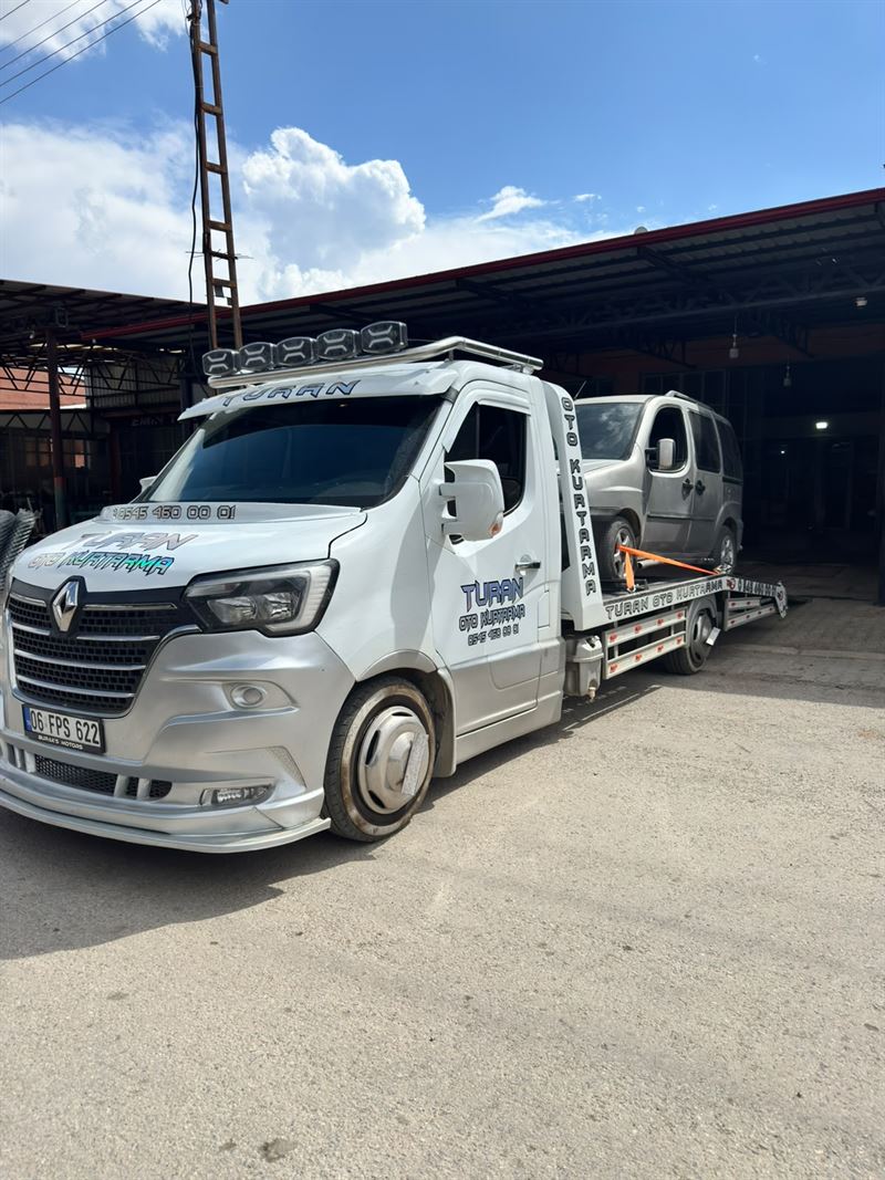 Sanayi alanında gri minibüsün çekiciye yüklenmesi