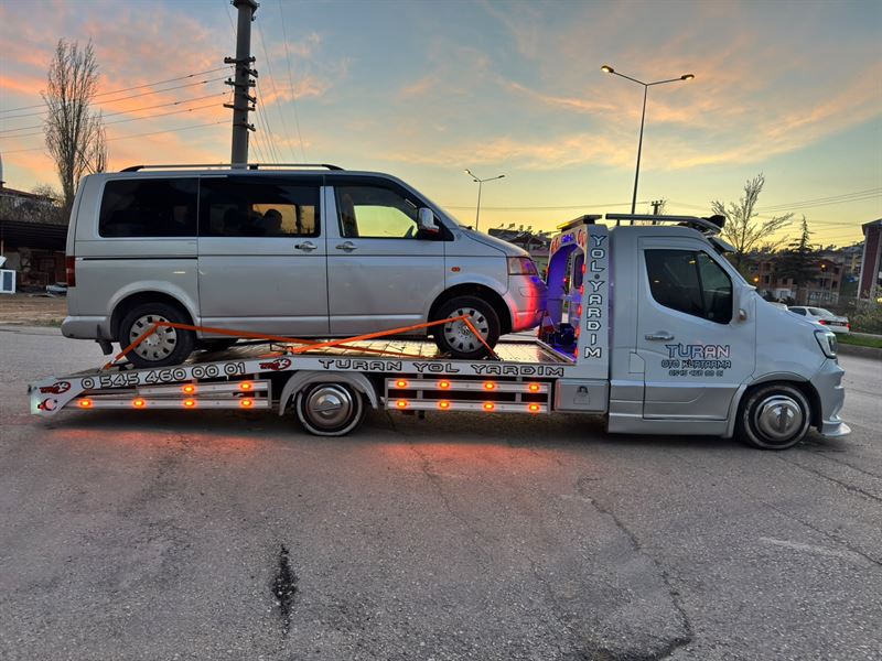 Gün batımında gri minibüs taşıyan Turan Oto Kurtarma çekicisi