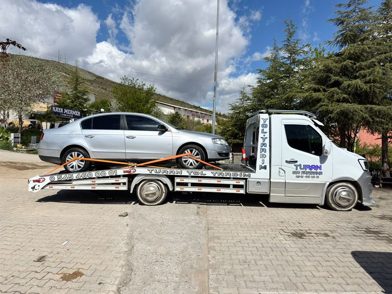 Gümüş renkli otomobilin Turan çekicisi üzerinde yandan görünümü