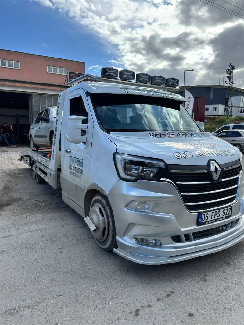 Beyaz Turan Oto Kurtarma çekicisi, ticari bina arkasında