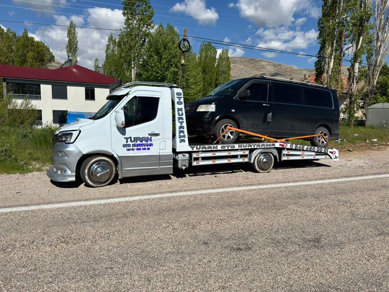 Kırsal yol kenarında siyah minibüs taşıyan Turan çekicisi