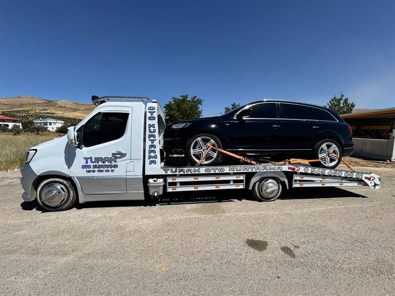 Siyah SUV taşıyan Turan çekicisinin yandan görünümü